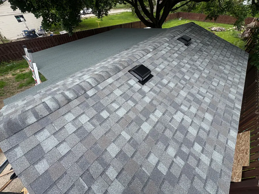 A finished grey architectural shingle roof with a roof vent and skylight.