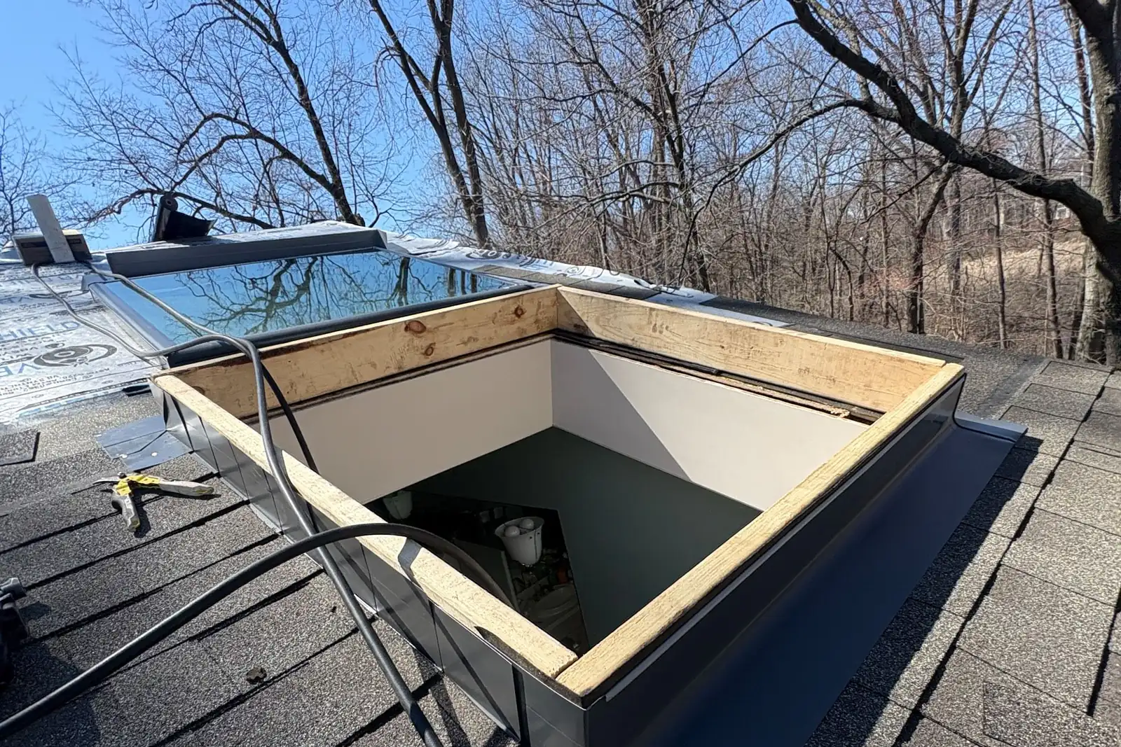 A framed skylight curb with new step flashing waiting for the glass unit.